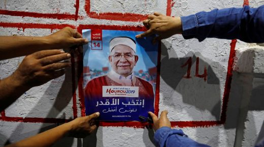 Supporters paste a presidential election campaign poster of Abdel Fattah Morou, vice-president of the moderate Islamist party Ennahda in Tunis, Tunisia September 2, 2019. REUTERS/Zoubeir Souissi