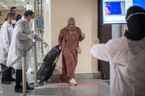 Moroccan health workers scan passengers arriving from Italy for coronavirus COVID-19 at Casablanca Mohammed V International Airport on March 3, 2020. (Photo by FADEL SENNA / AFP)