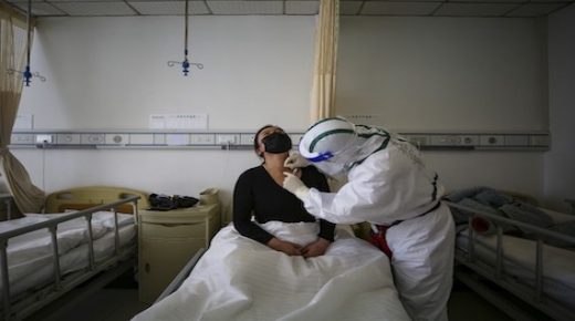 A patient (L) infected by the COVID-19 coronavirus receives acupuncture treatment at Red Cross Hospital in Wuhan in China's central Hubei province on March 11, 2020. - China reported an increase in imported coronavirus cases on March 11, fuelling concerns that infections from overseas could undermine progress in halting the spread of the virus. (Photo by STR / AFP) / China OUT