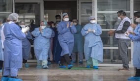 Members of the medical staff rejoice as patients who recovered from the Covid-19 disease caused by the novel coronavirus, leave a hospital in the city of Sale, north of the Moroccan capital Rabat, on April 12, 2020. (Photo by FADEL SENNA / AFP)