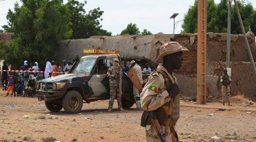 A Malian soldiers stand beside a destroyed building on November 13, 2018, in Gao, after a suicide car bomb attack overnight, which killed three people. - Three Malian civilians were killed and around 30 people were wounded in a suicide attack late on November 12 in the country's violence-hit north, officials said, as a diplomat said some of the injured were sub-contractors for the UN. The attack took place in the city of Gao when a 4x4 vehicle blew up in a residential area, the security ministry said in a statement. The blast was claimed by the GSIM, the main jihadist group operating in the Sahel region. It has ties to Al-Qaeda and was blacklisted by Washington in September. (Photo by - / AFP)